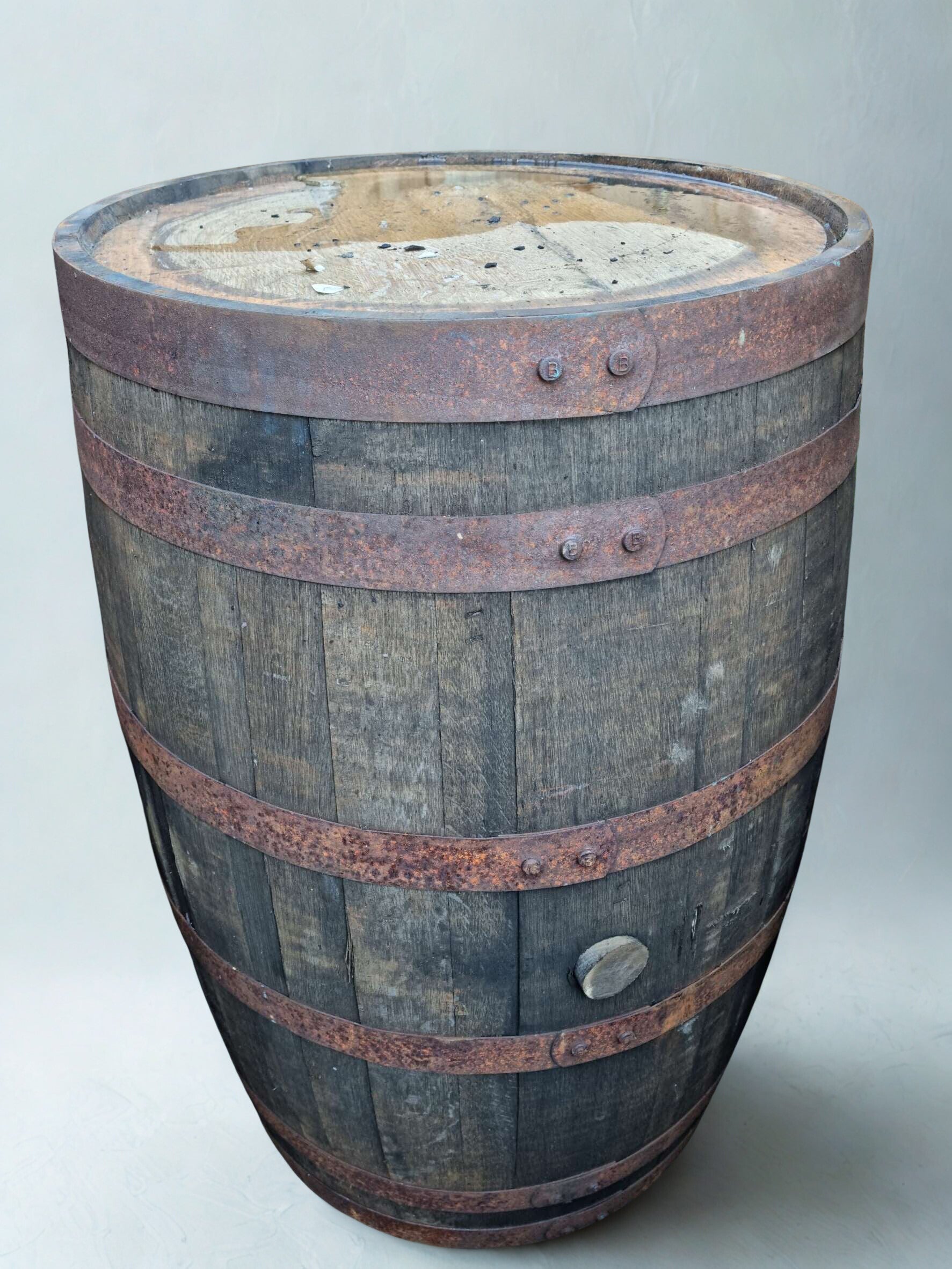 Wooden barrel with metal bands on a light gray background