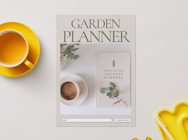 Garden planner book with a cup of tea and yellow saucer on a white surface