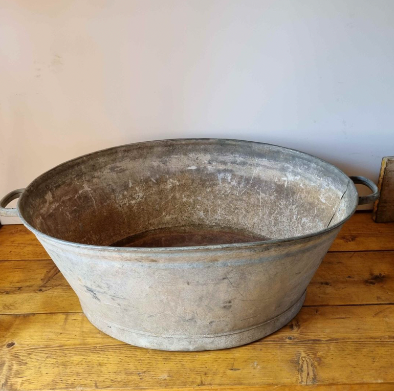 Vintage metal basin on a wooden surface with a plain background