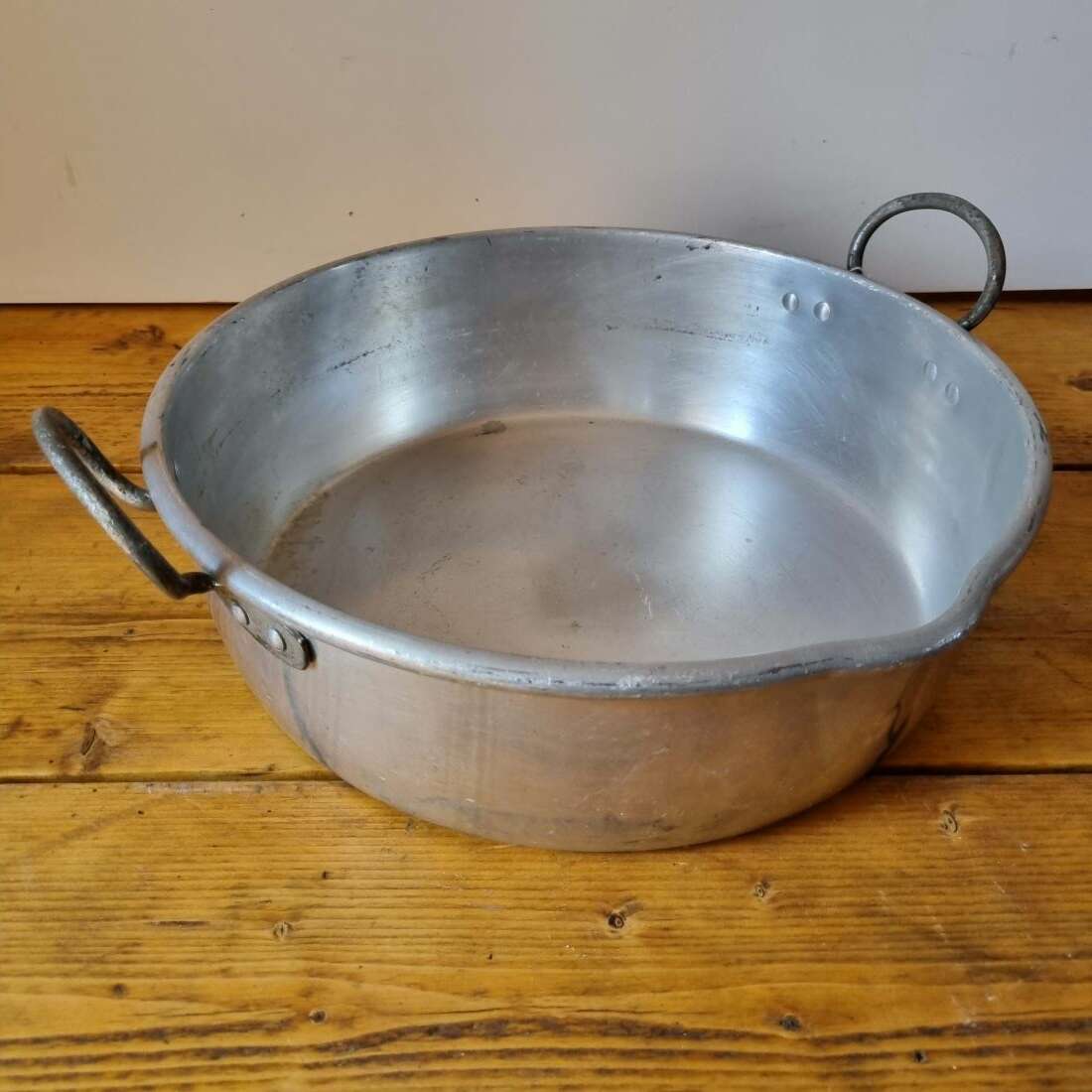 Aluminum pot with handles on a wooden surface